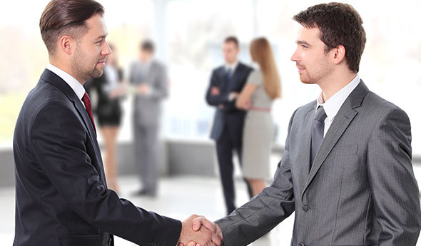 Zwei Männer in Anzügen schütteln sich die Hände