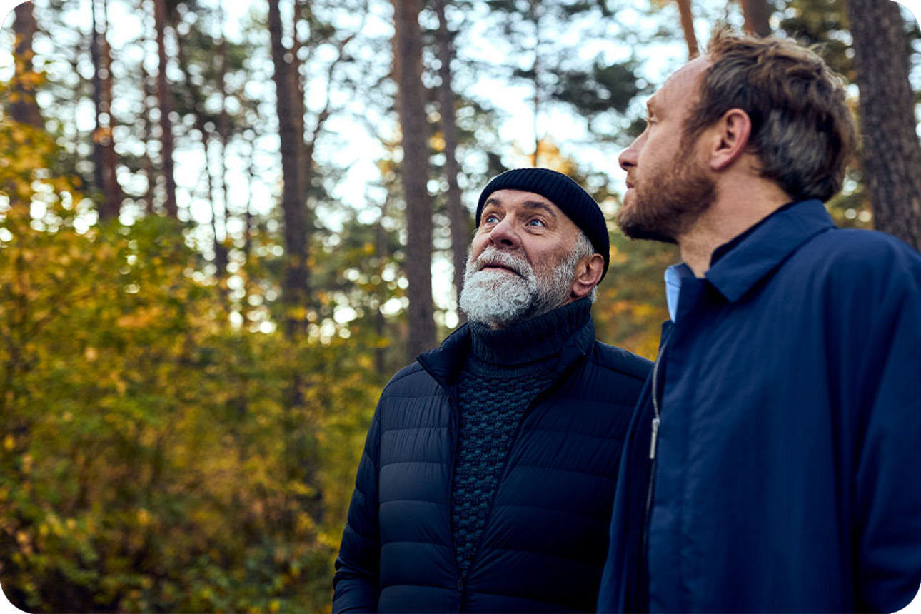 Ein älterer und ein jüngerer Mann im Wald