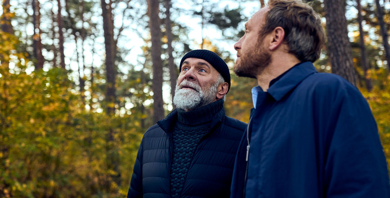 Ein älterer und ein jüngerer Mann im Wald