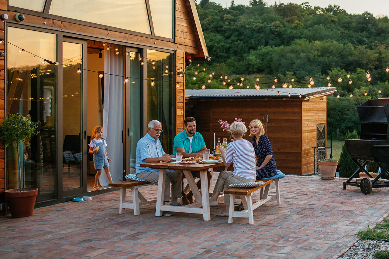 Eine Familie sitzt um einen Tisch auf einer Terasse
