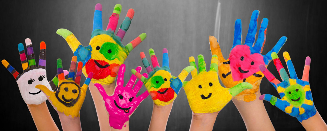 Hochgestreckte mit Smileys bunt bemalte Hände