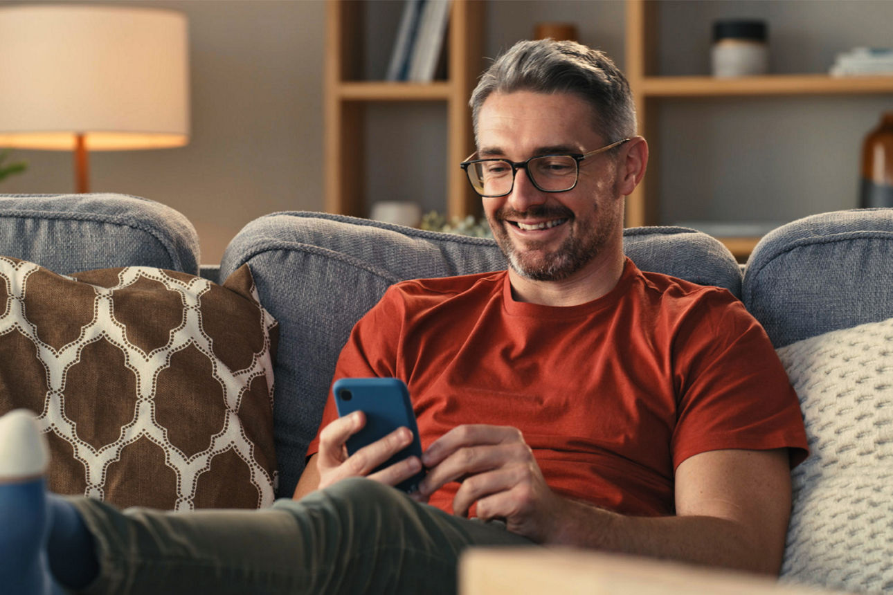 Mann sitzt entspannt auf der Couch