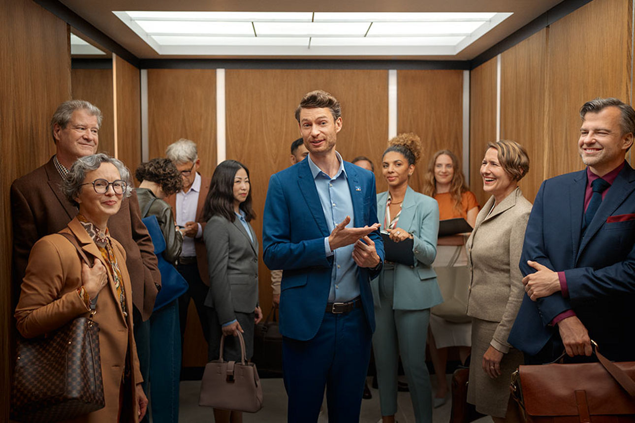 Mann im Fahrstuhl mit vielen weiteren Personen