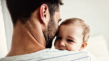 Baby in den Armen des Vaters