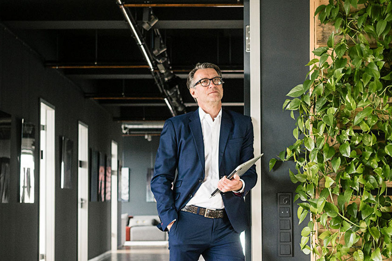 Mann steht vor grünem Hintergrund