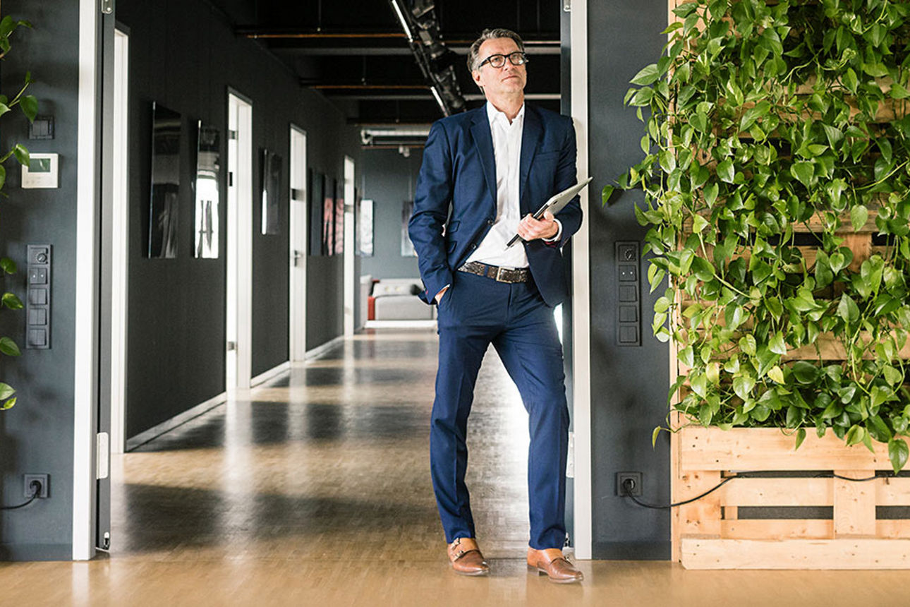 Ein Mann im Anzug steht nachdenklich im Raum 