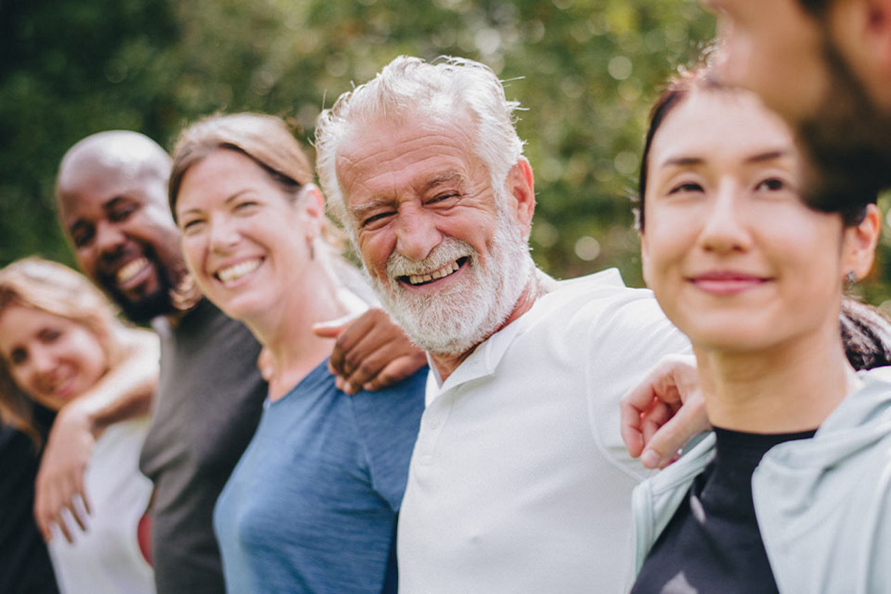 Menschen stehen in einer Reihe und haben sich im arm
