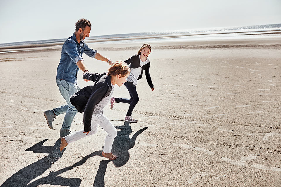 Menschen laufen am Strand