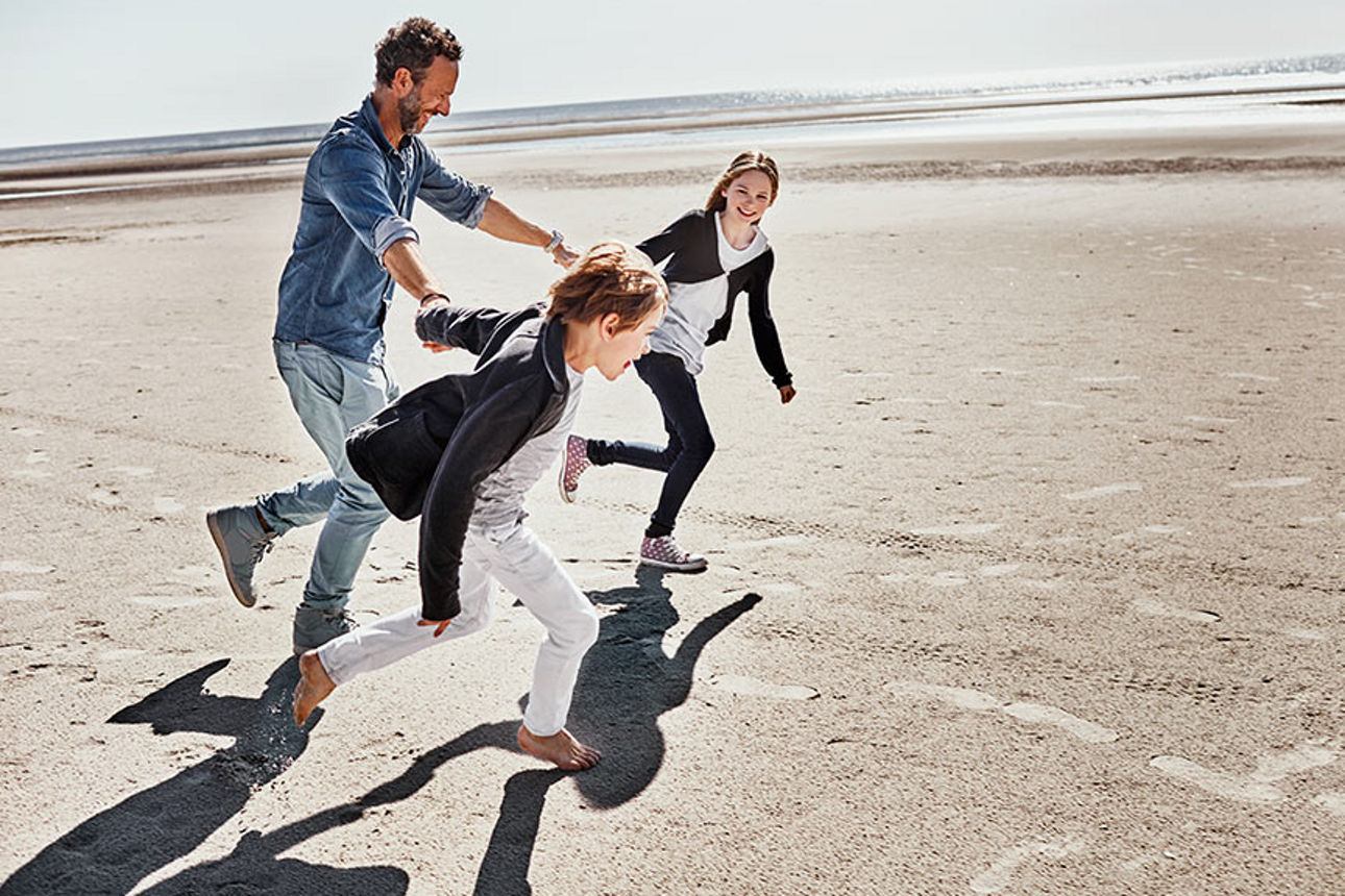 Menschen laufen am Strand