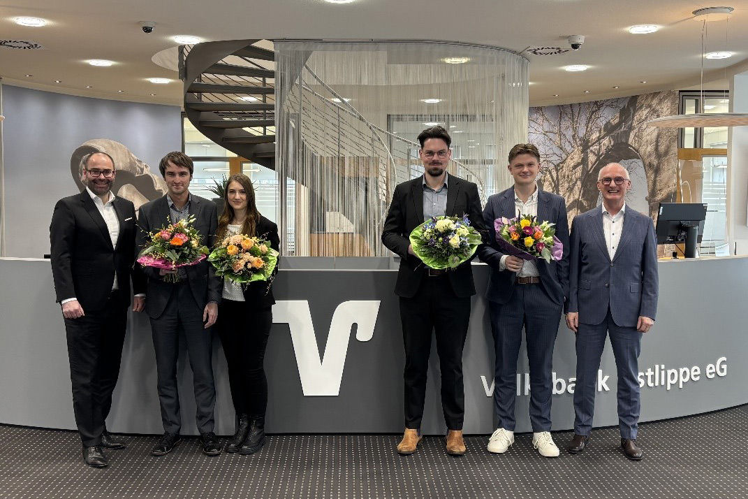 Sechs Personen posieren in Innenräumen der Bank