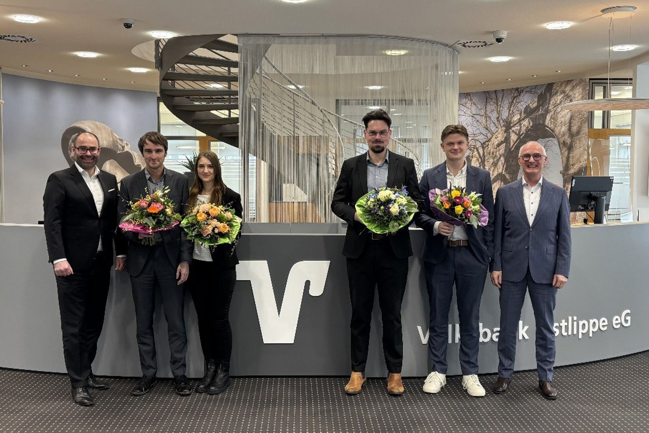 Sechs Personen, vier davon halten einen Blumenstrauß