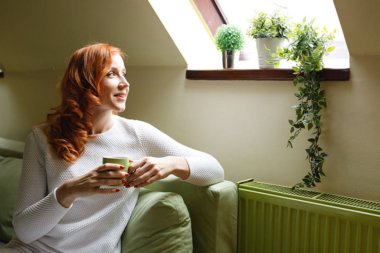 Frau, die unter einem Fenster sitzt