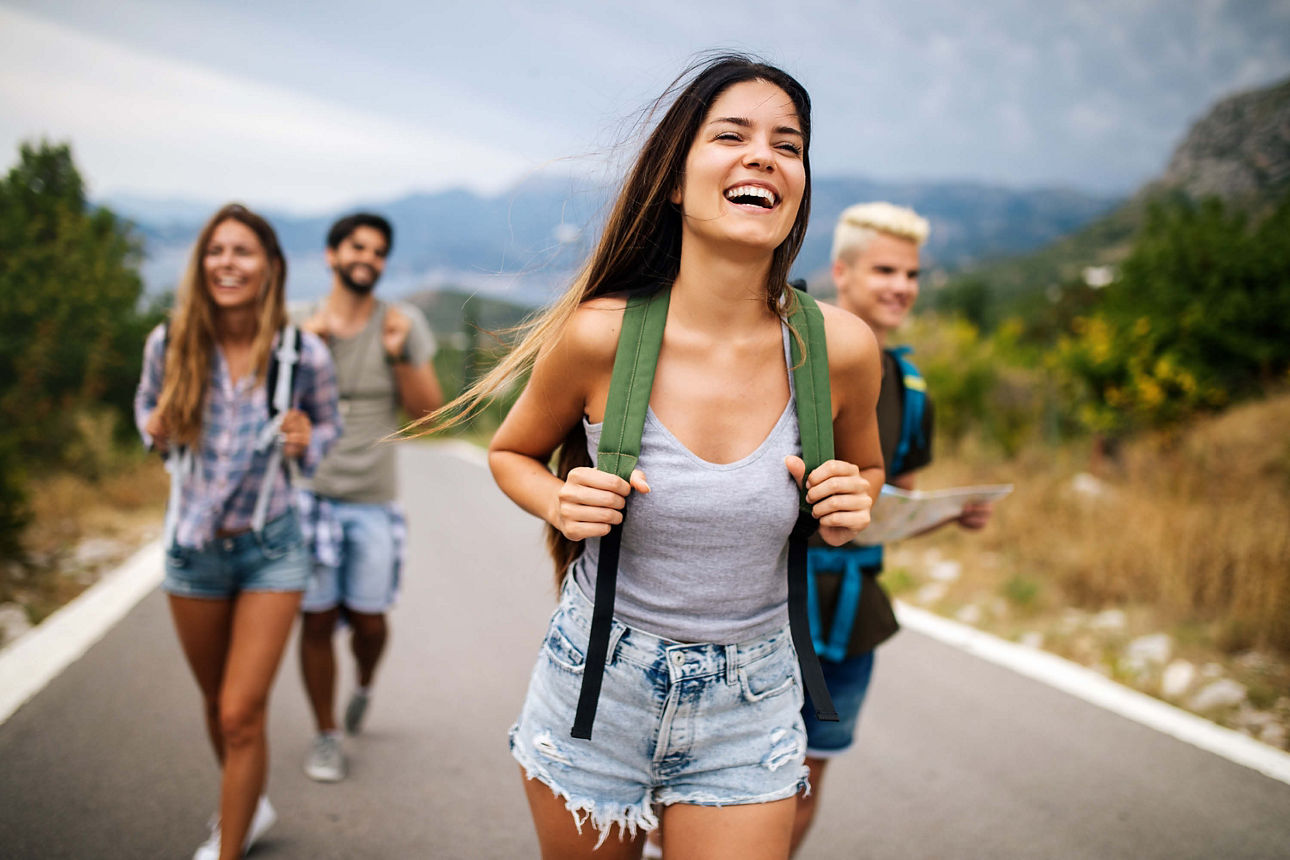 Gruppe junger Leute bei einer Wanderung auf der Landstraße