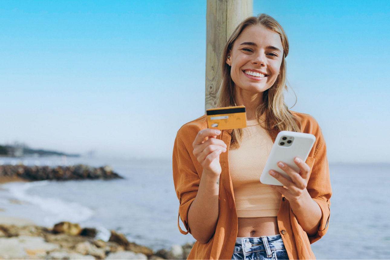 Junge Erwachsene zahlt digital am Strand