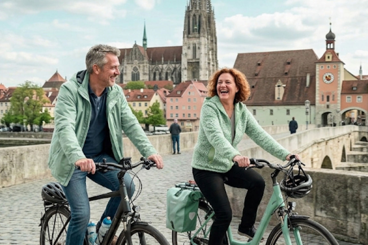 Paar fährt mit dem Fahrrad über die steinerne Brücke