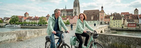 Eine Frau und ein Mann radeln durch Regensburg