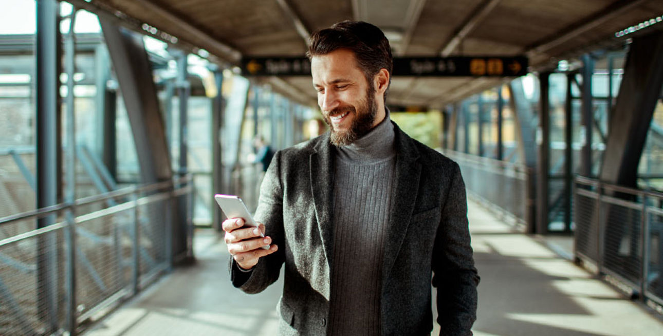 Ein Mann ist unterwegs mit seinem Smartphone.