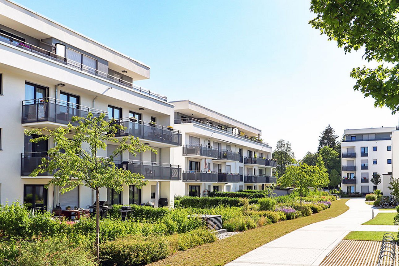 Gebäudekomplex mit Wohnungen, umgeben von Grünanlagen