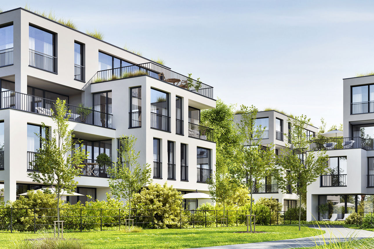 Neue weiße Wohngebäude mit großen Fenstern und Grünfläche vorm Haus