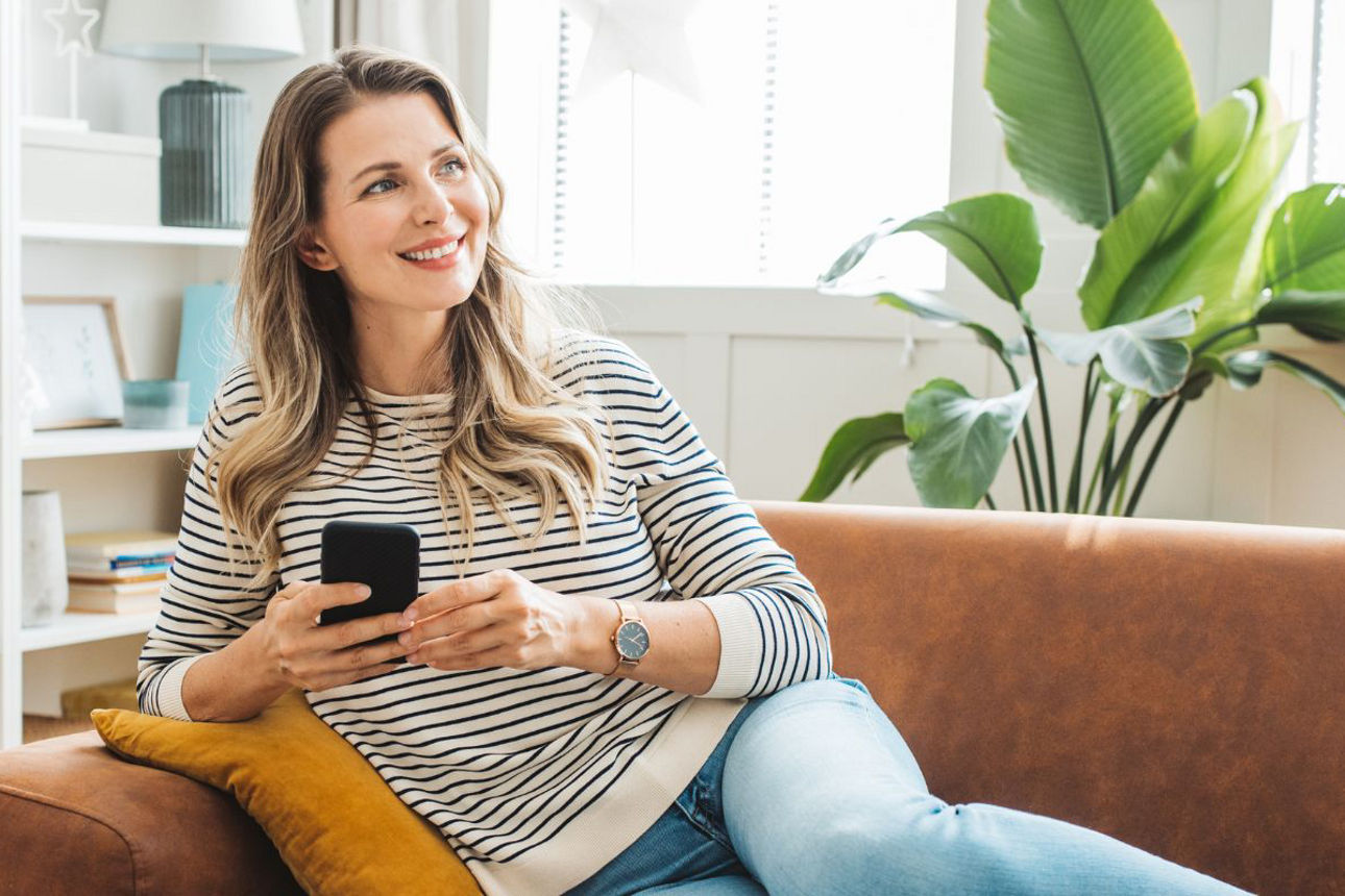 Frau am Handy auf Couch