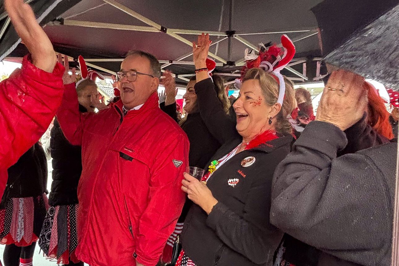 Unter dem Popup-Zelt reißen die Narren die Arme für ein Alaaf in die Höhe