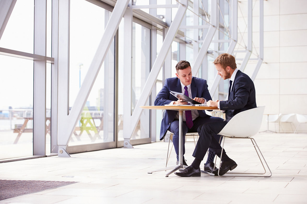 Zwei Kollegen aus der Finanzbranche besprechen Factoring Verträge