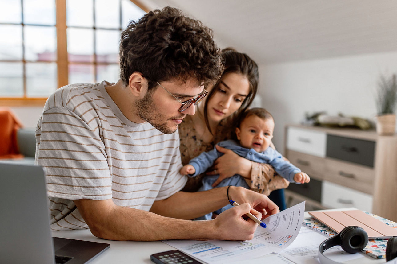 Eine junge Familie plant ihr monatliches Familienbudget.
