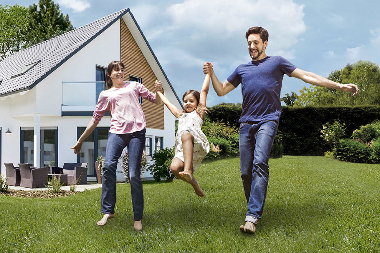 Familie freut sich vor dem Haus