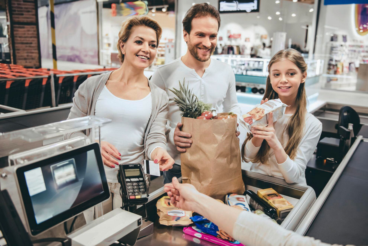 Familie beim Bezahlen an der Supermarktkasse