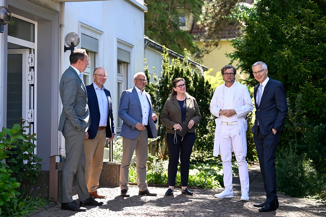 Sechs Personen stehen neben Eingangstür