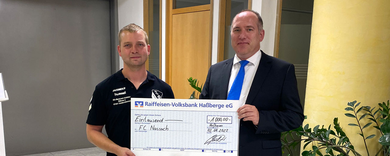 Alexander Rauschert übergibt einen Spendenscheck an den FC Nassach