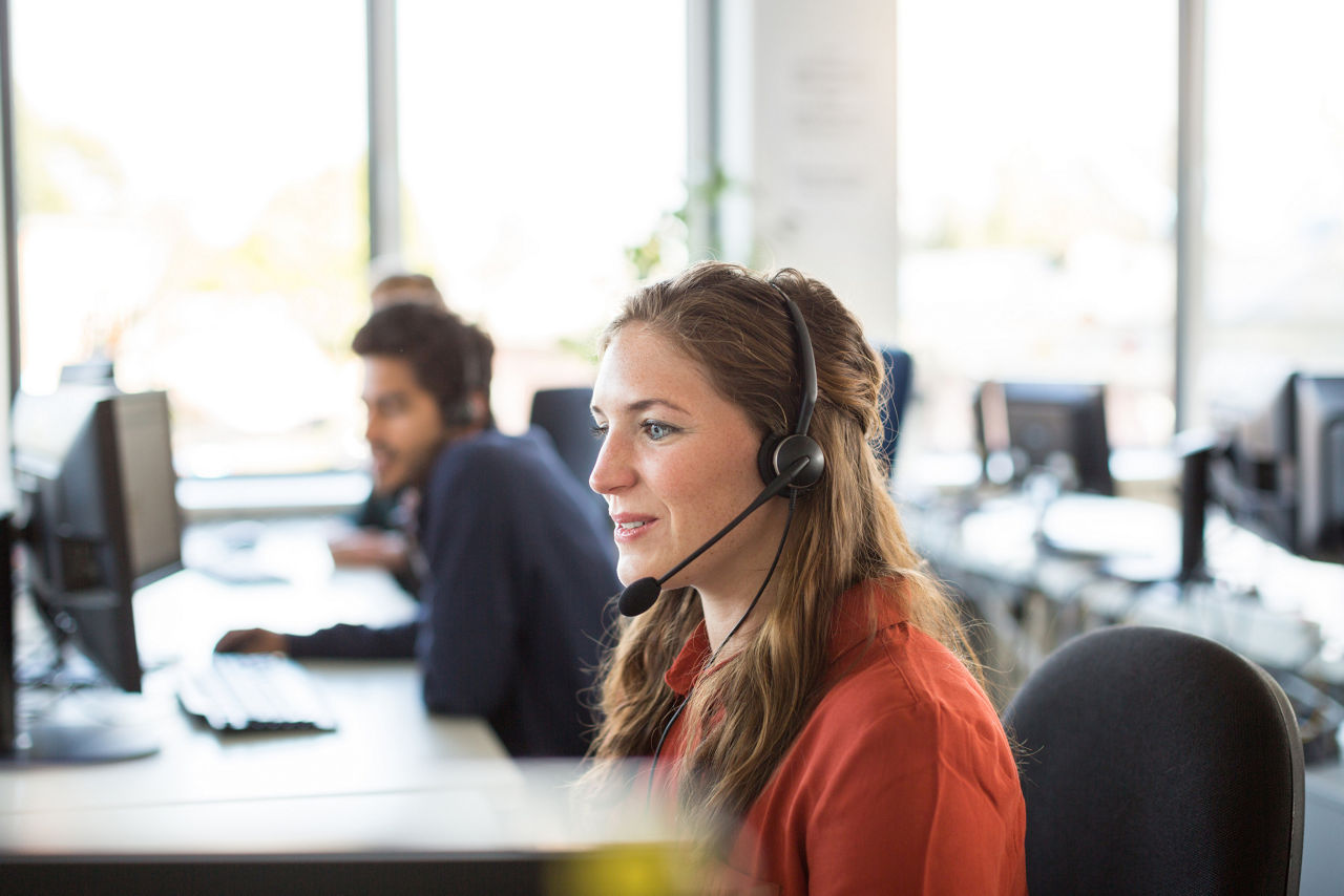 Frau mit Headset am PC