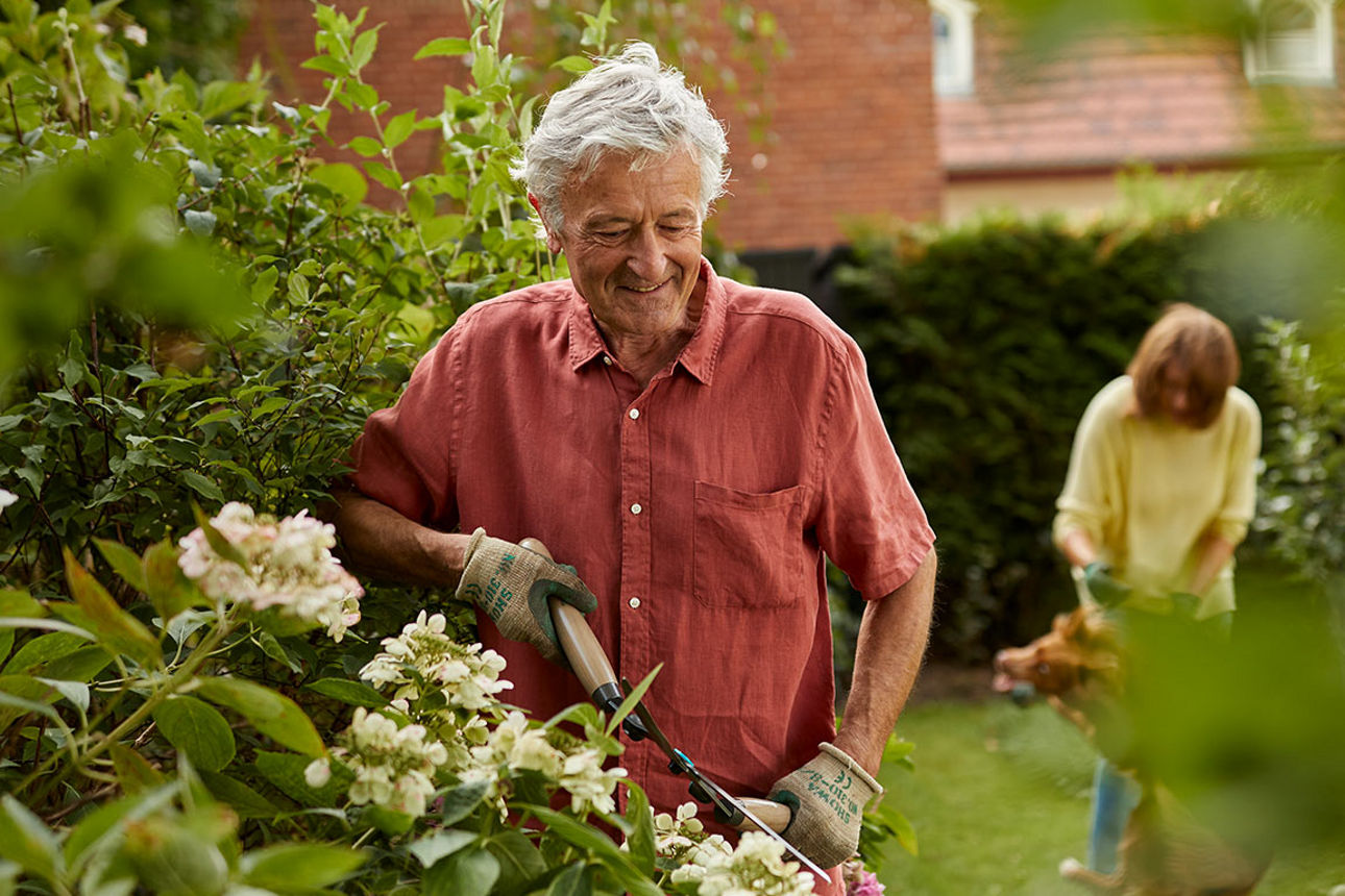 Ein Mann arbeitet glücklich in seinem Garten