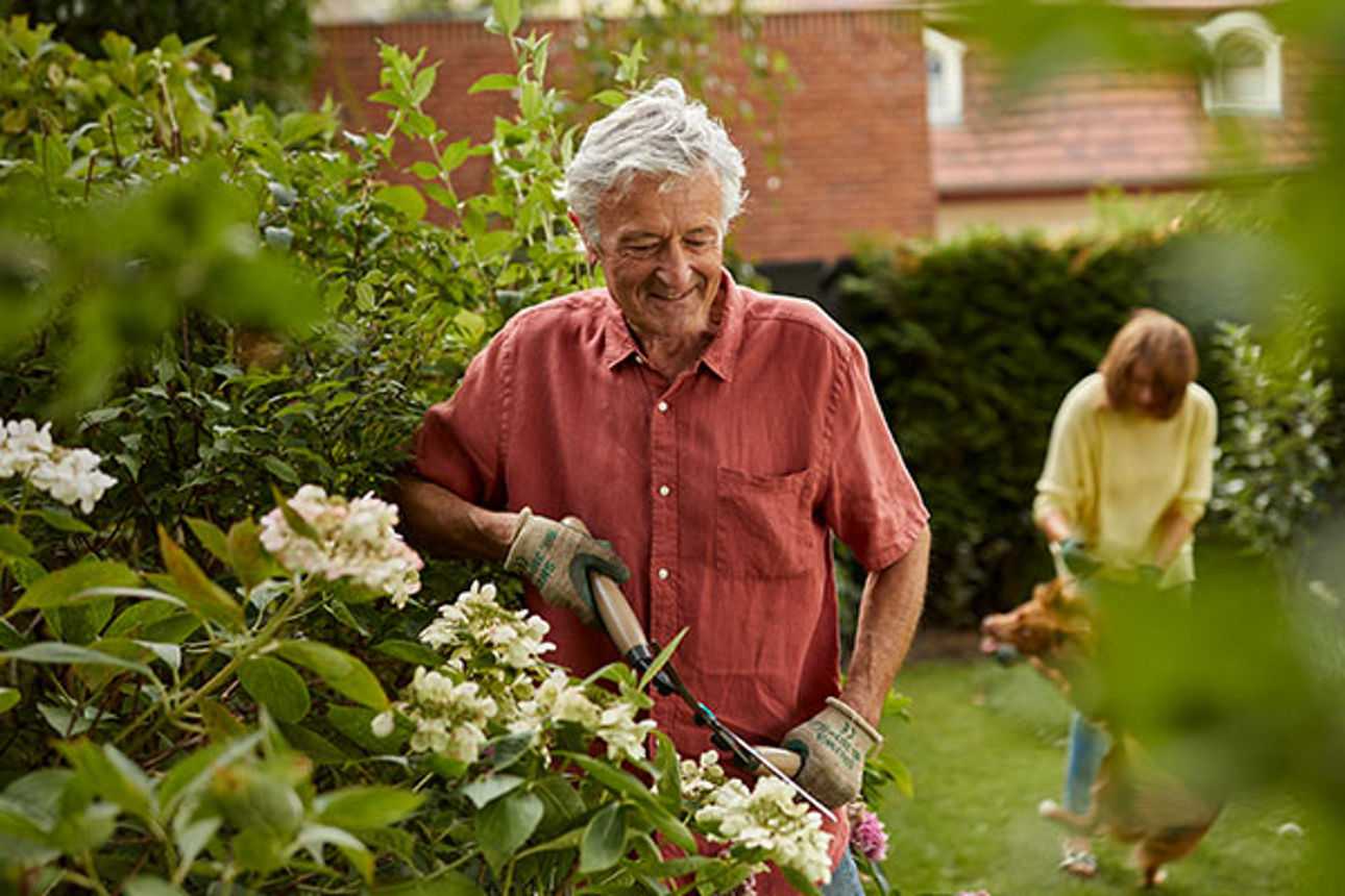 Ein Mann arbeitet glücklich im Garten