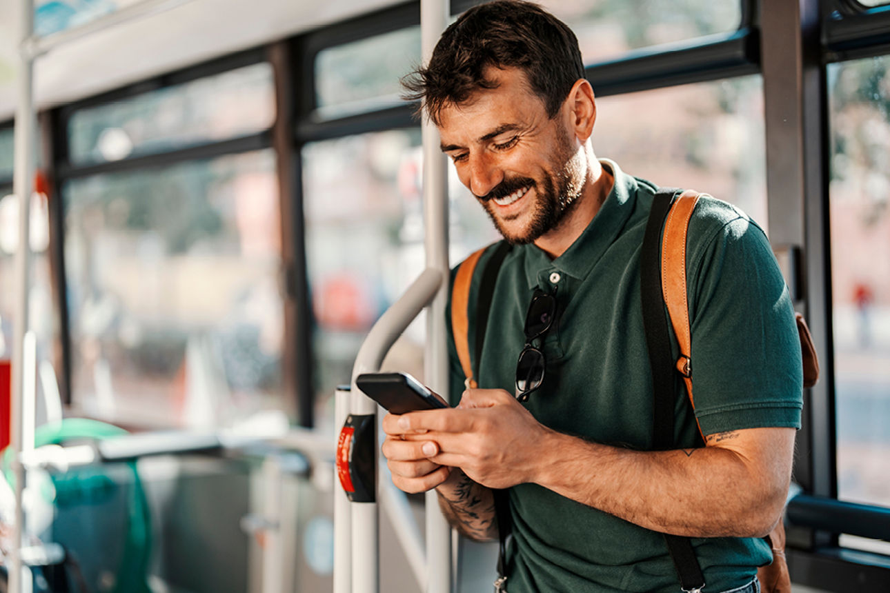 Mann schaut im Bus auf sein Handy