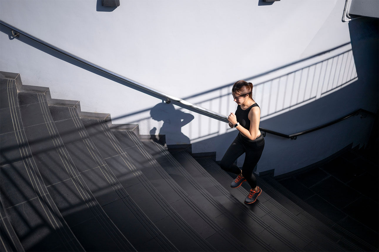 Sportliche Frau die ein paar Treppen hoch joggt