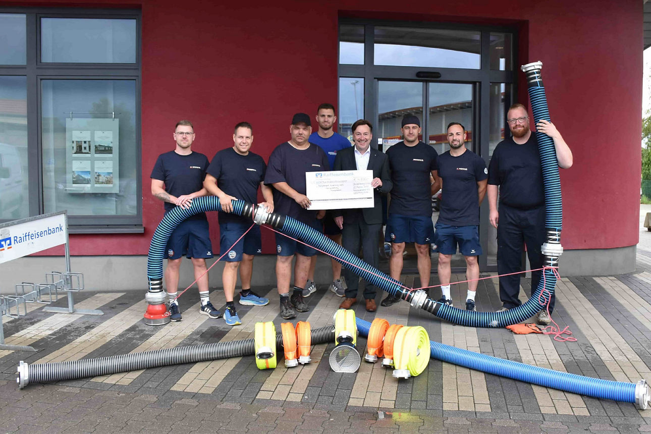 Mitglieder vom Feuerwehrsport Boizenburg-Land präsentieren neues Trainingsmaterial vor der Filiale der Raiffeisenbank eG