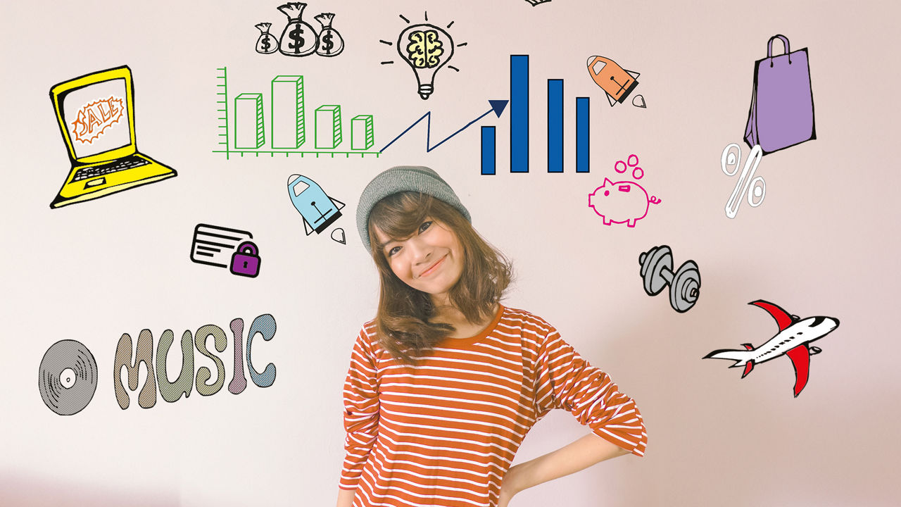 Junges Mädchen mit grauer Beanie-Mütze steht vor einer Wand mit Finanz-Doodles