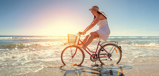Frau auf einem Rad fährt durchs Meer