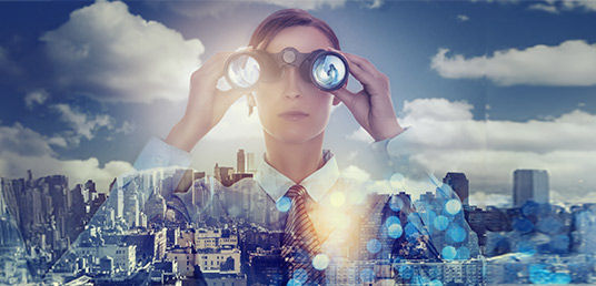 Frau mit Fernglas schaut in die Ferne