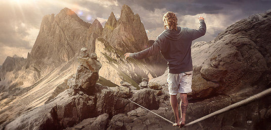 Mann auf einer Slackline über Berge