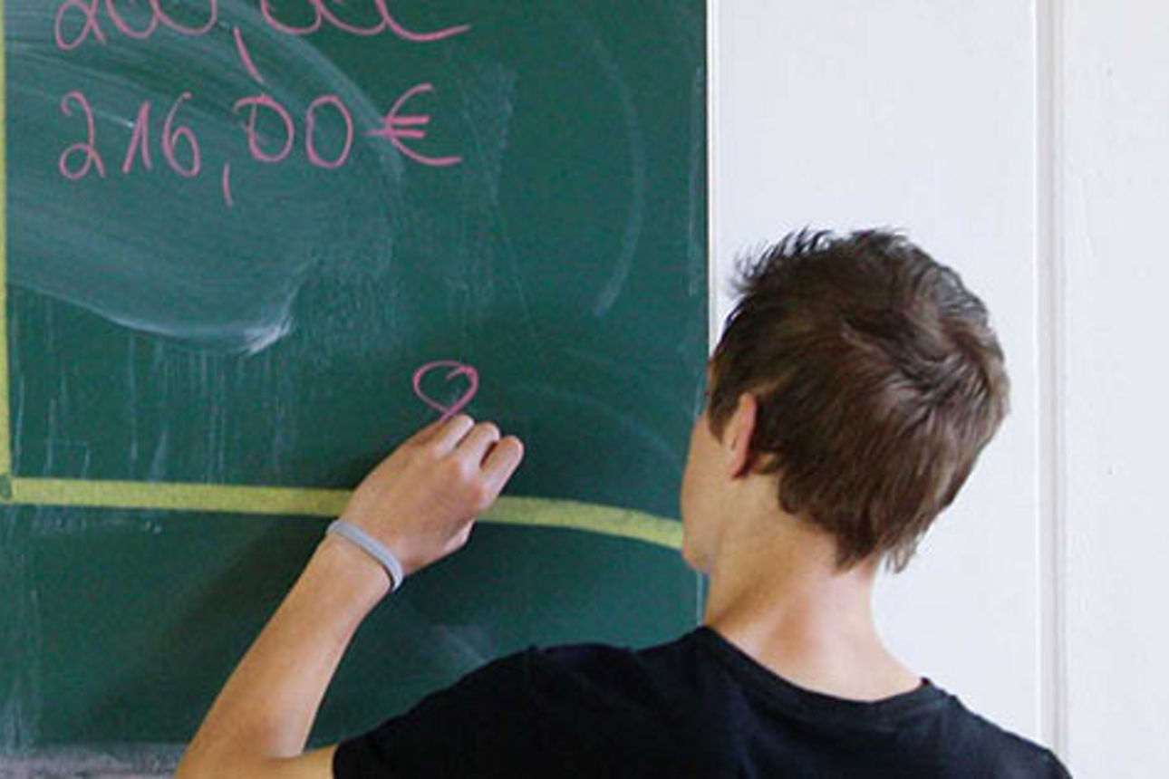  Ein Junge schreibt an einer Tafel