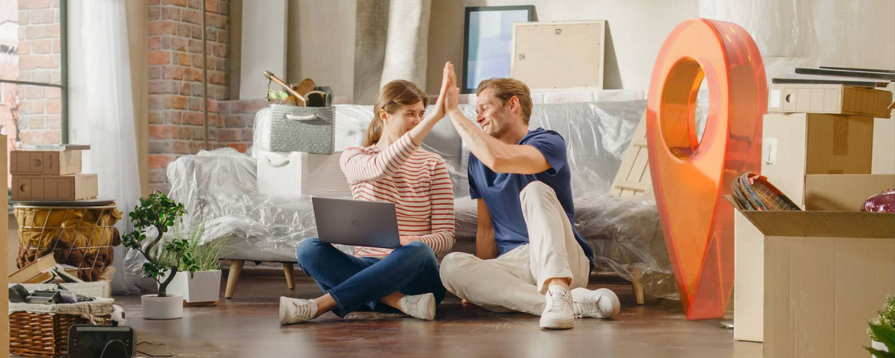 Junges Paar geben sich in ihrer neuen Wohnung ein High-Five