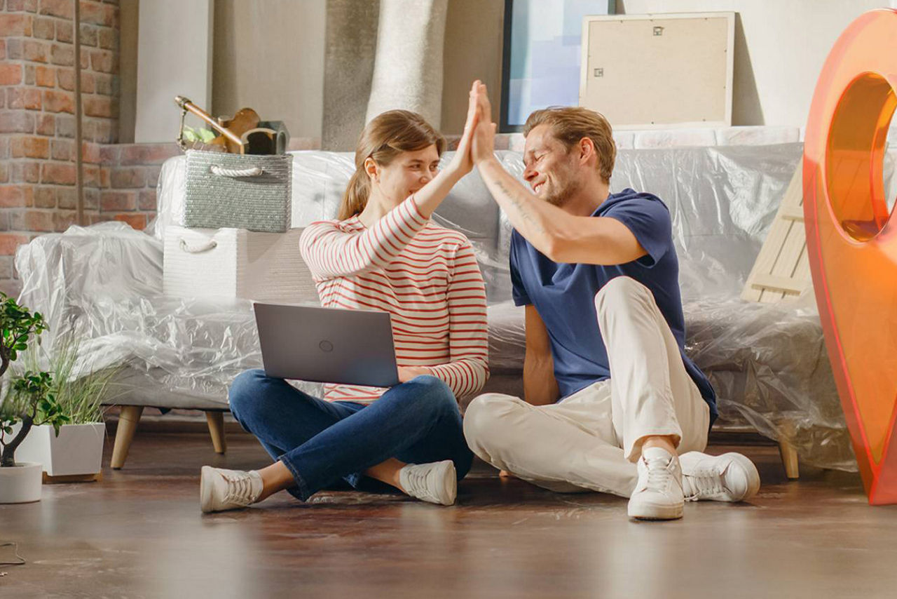 Junges Paar geben sich in ihrer neuen Wohnung ein High-Five