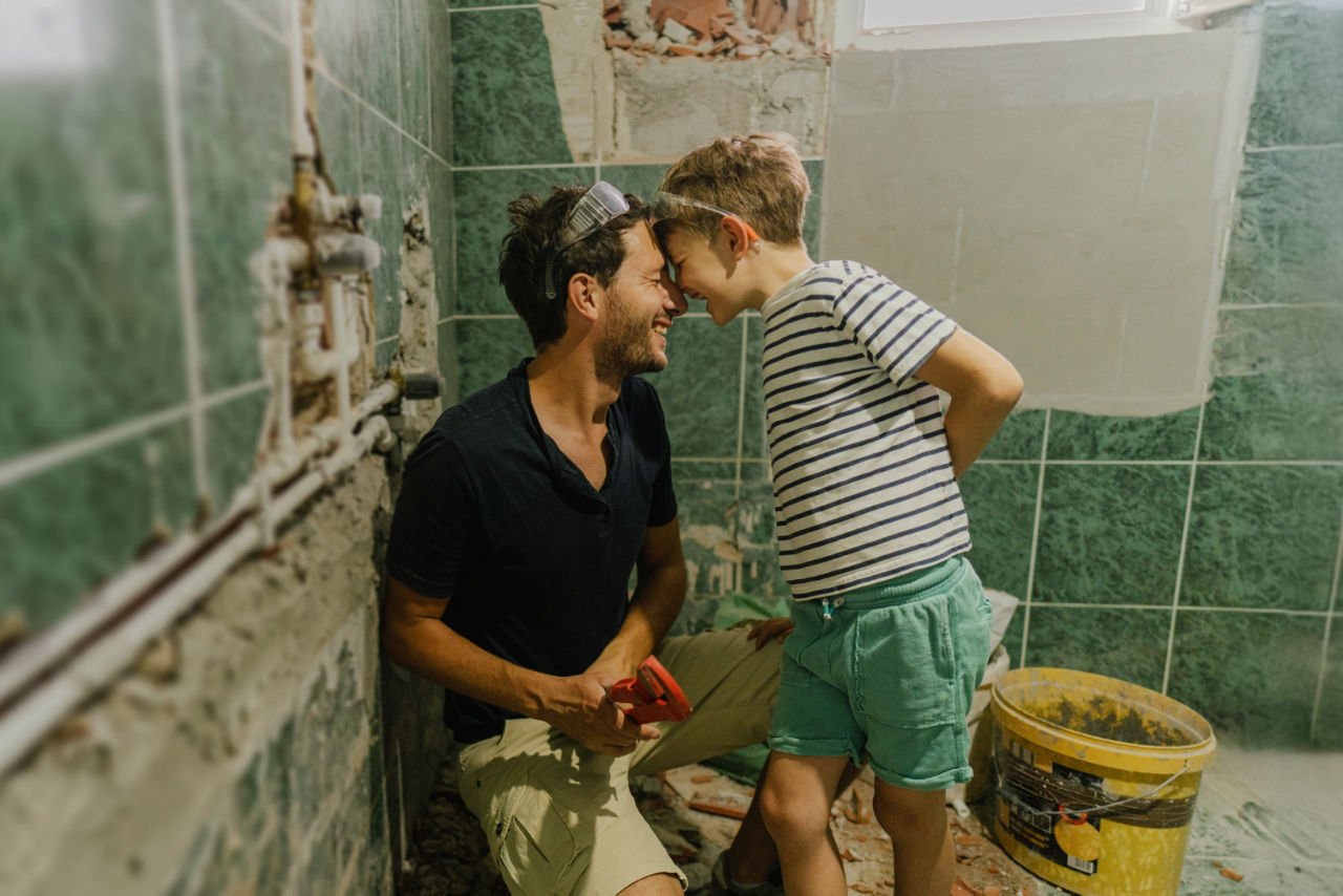 Vater und Sohn auf der Baustelle beim Renovieren des Badezimmers