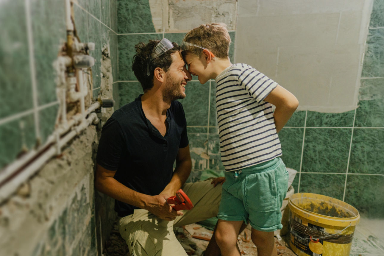 Vater und Sohn auf der Baustelle beim Renovieren des Badezimmers