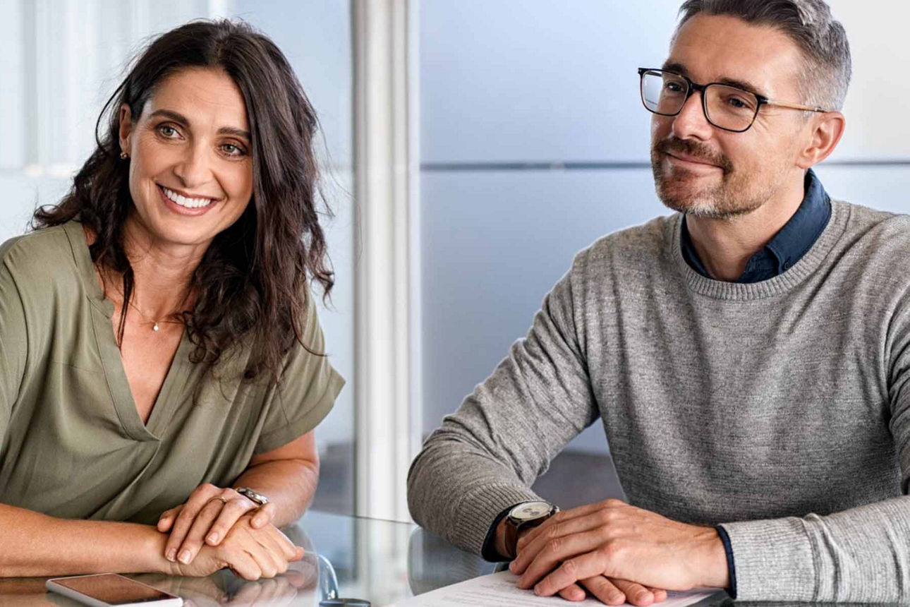 Mann und Frau sitzen glücklich in einer Beratung