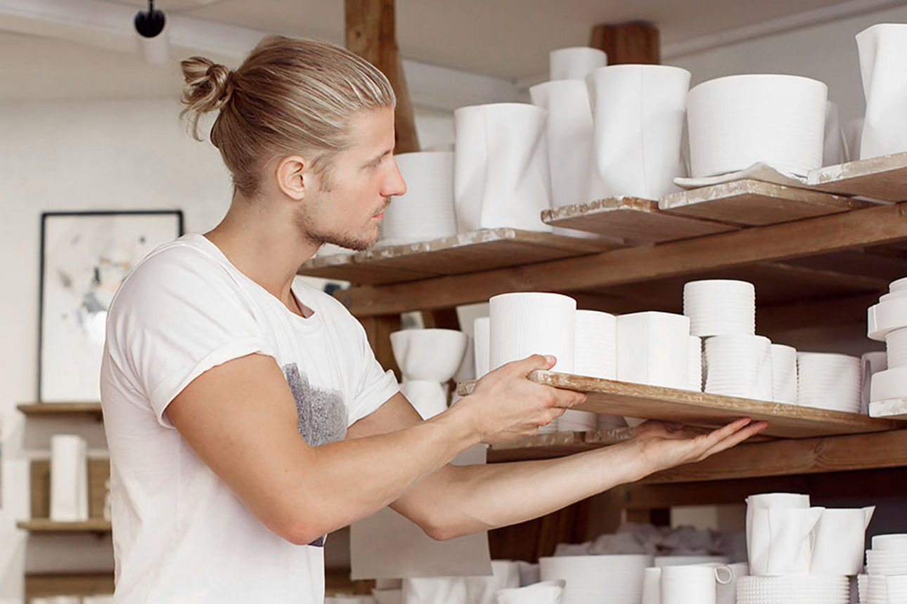 Älterer Mann sitzt lachend auf Landmaschine