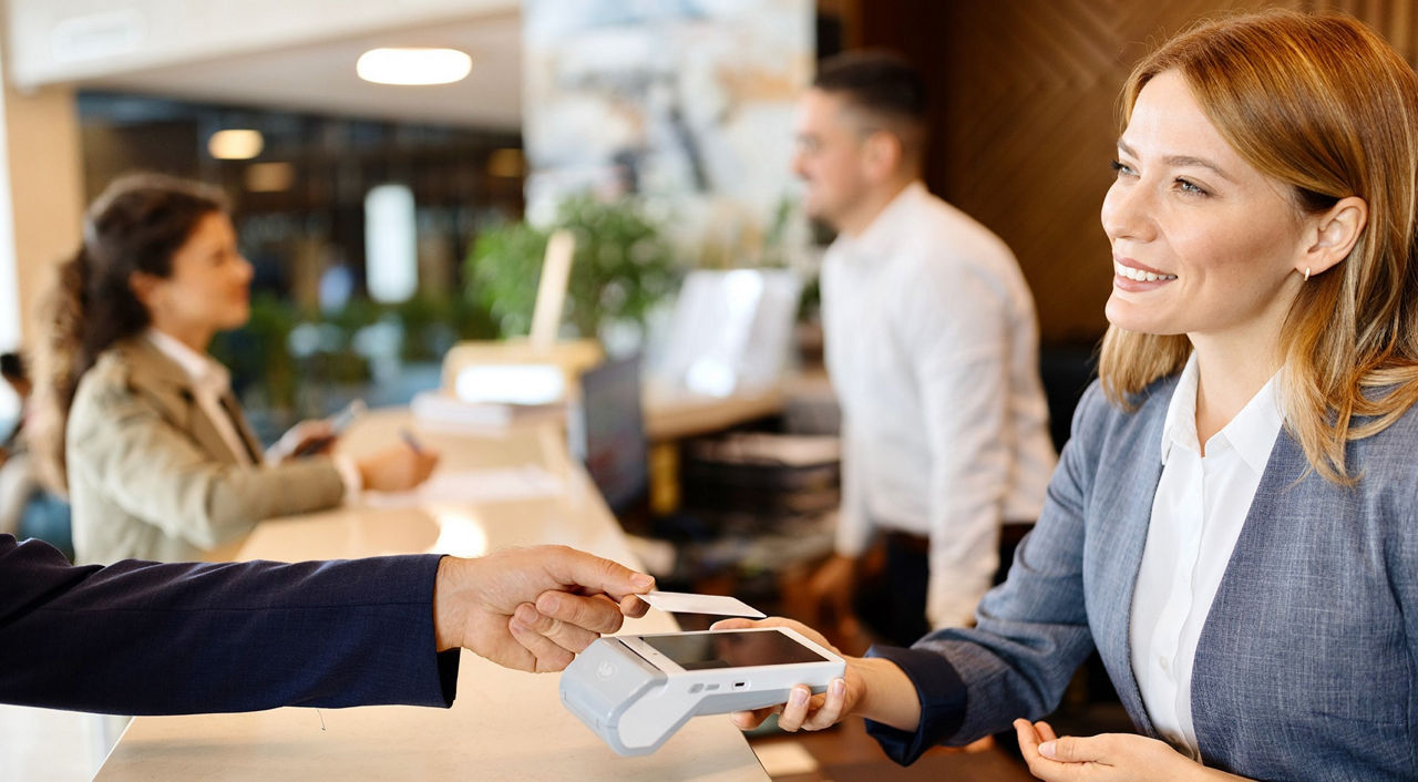 firmenkredtikarte-mastercard-gold-volksbank-raiffeisenbank-frau-zahlt-rezeption