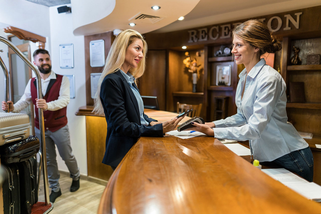 firmenkredtikarte-mastercard-gold-volksbank-raiffeisenbank-frau-zahlt-rezeption